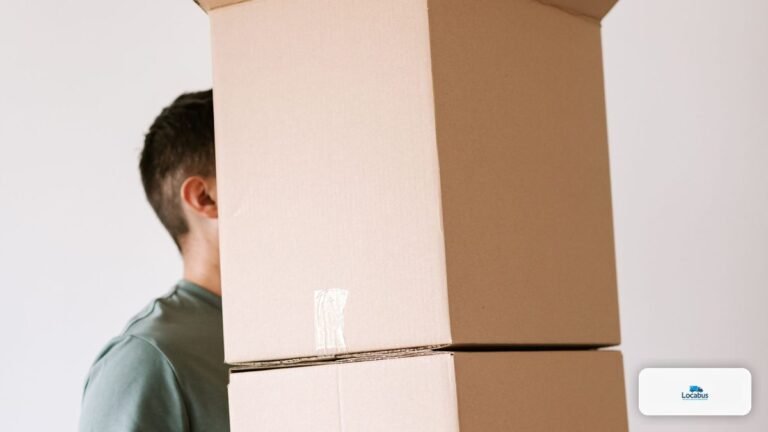 Homme portant seul une pile de cartons de déménagement