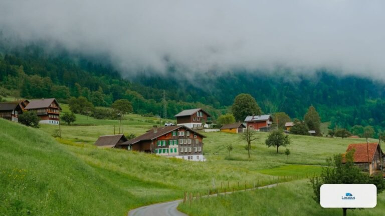 Route de campagne et village du Jura bernois sous un ciel nuageux