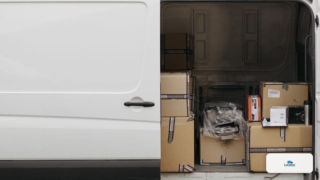 Intérieur d'un fourgon chargé de cartons de déménagement, portes ouvertes